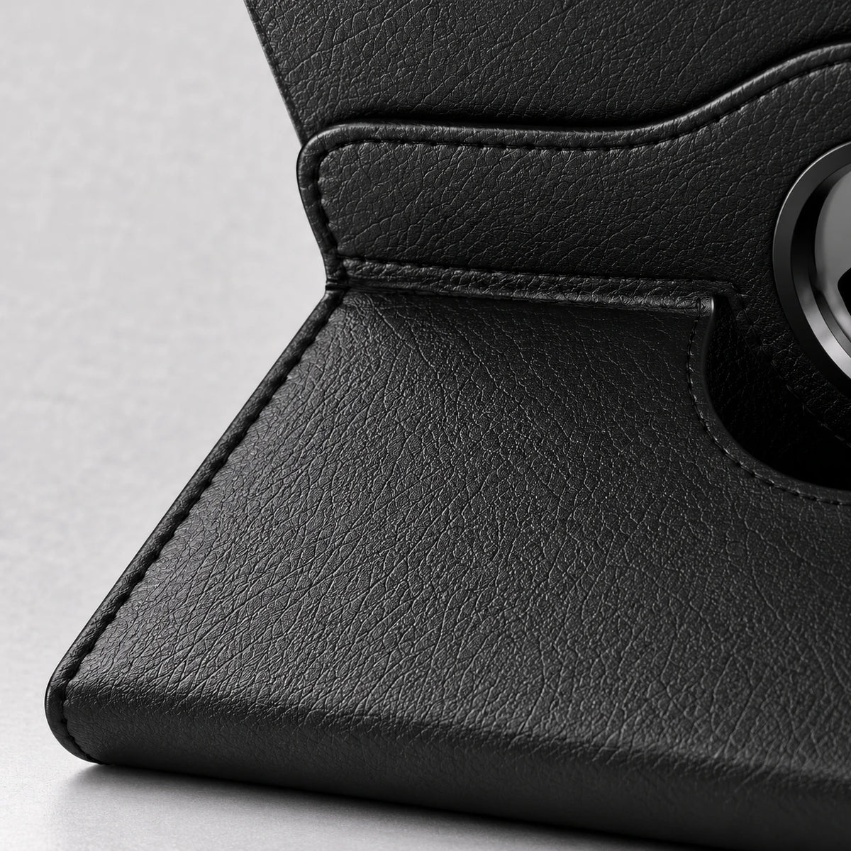 Close-up of textured black PU leather and stitching on a tablet folio.