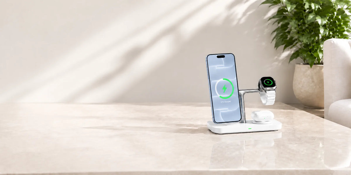 White wireless charging station holding a light blue phone, watch and earbuds.
